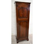 A 1950s mahogany veneered single door wardrobe, the single panelled door with mirror to the interior