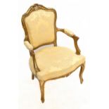 An early 20th century French fauteuil with gilt heightened frame, padded back, arms and seat and