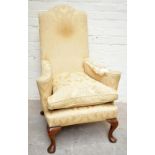 A George II style wing back chair, with floral yellow upholstery, on cabriole legs, height 112cm.