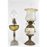 A Victorian-style oil lamp with amber and etched glass shade above a brass and ceramic base and one