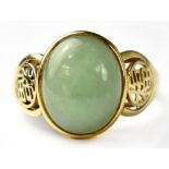 A 14ct yellow gold fashion ring set with central jade cabochon flanked with pierced Chinese symbols