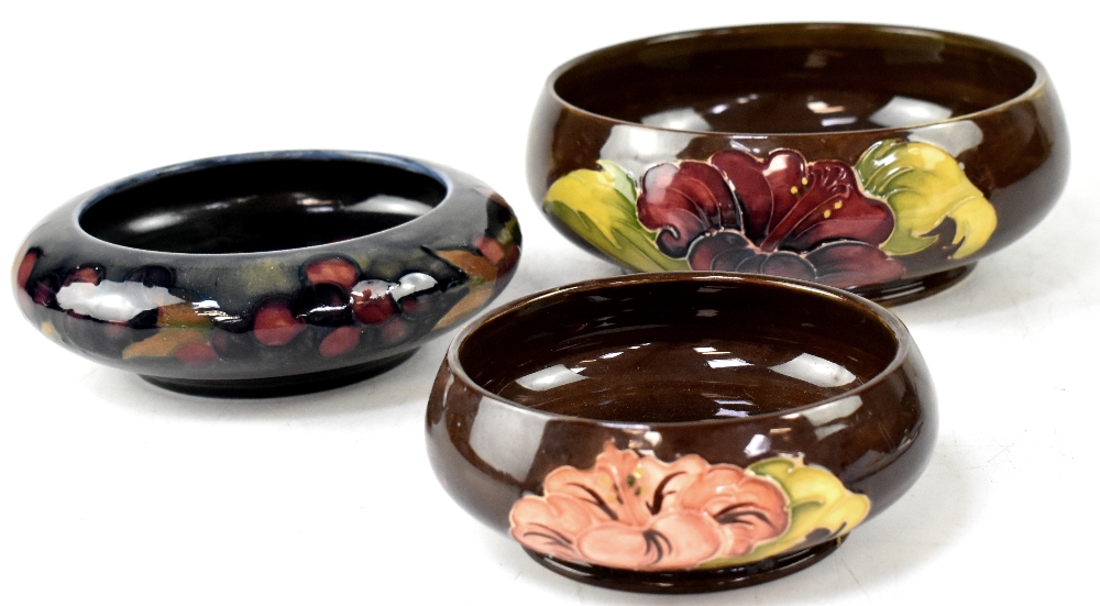 Three Moorcroft bowls, two brown ground with tube-lined hibiscus decoration,