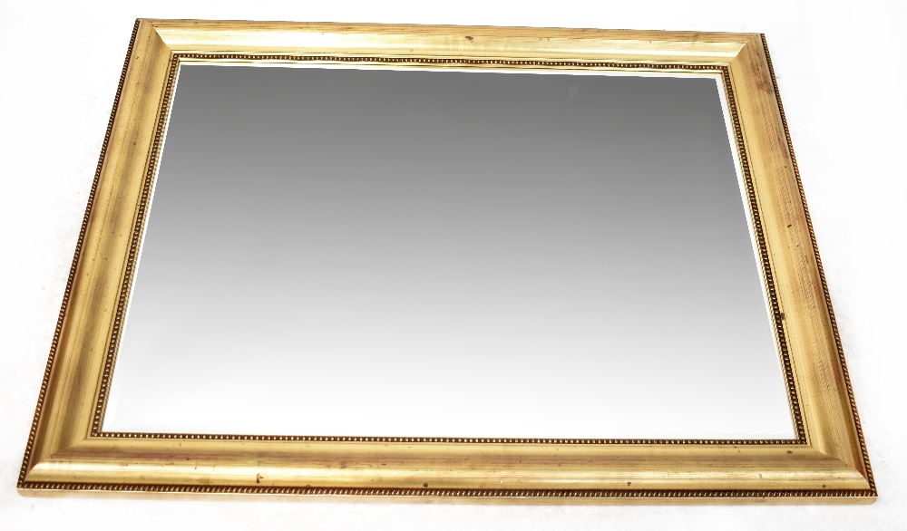 A large gilt framed rectangular bevel-edged wall mirror with bead decoration to the frame,