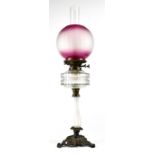 An Edwardian-style oil lamp, cranberry glass style opaque shade to clear reserve,