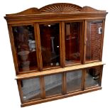 A large late Victorian oak bookcase with shell carved pediment above four glazed doors enclosing