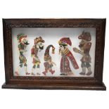 Five Thai puppets mounted within an illuminated wooden display box,