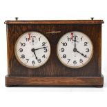 A vintage wooden cased chess clock, white enamel dials with Arabic numerals,