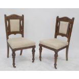 A set of four Victorian carved walnut salon chairs upholstered in studded cream suedette,