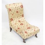 A Victorian walnut nursing chair upholstered in a modern embroidered satin fabric with red flowers,