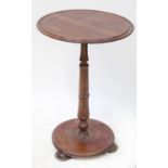 An early 20th century walnut circular topped occasional table on turned column,