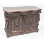 A 19th century carved oak sideboard with Green Man motifs to the frieze drawer,