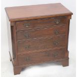 A 19th century mahogany chest of small proportions with four graduated long drawers flanked by