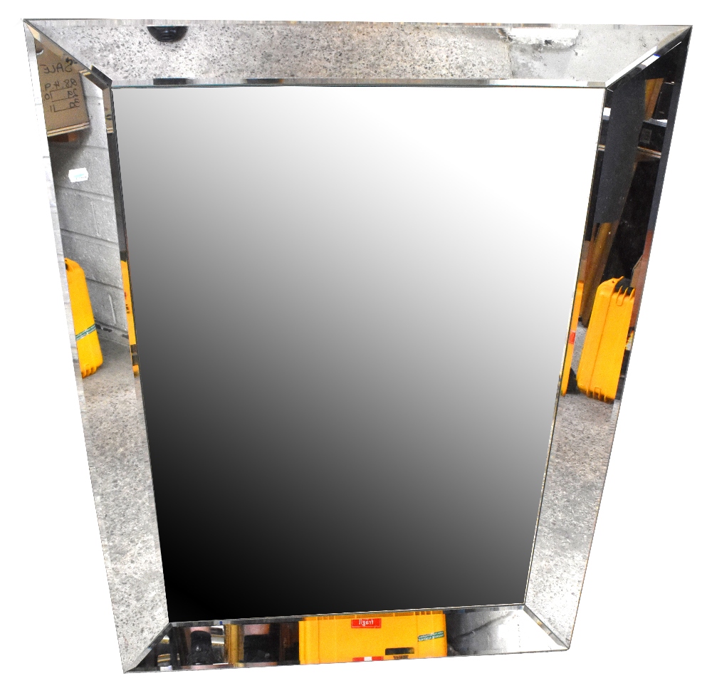 A large rectangular bevelled glass wall mirror with bevelled glass frame, 87 x 117cm.