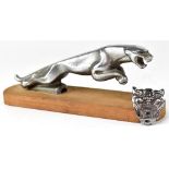 A Jaguar car mascot on rectangular oval wooden stand and a Jaguar car badge (2).