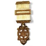 A 9ct gold Masonic medal with pierced star, square and compass within a circular border, with motto,