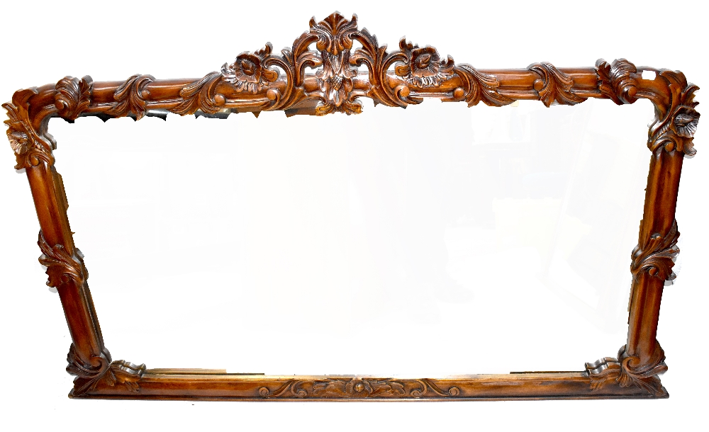 A carved mahogany overmantel mirror with foliate and floral surmount above a rectangular plate,
