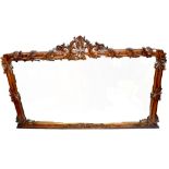 A carved mahogany overmantel mirror with foliate and floral surmount above a rectangular plate,