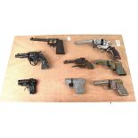 A wooden display board showing eight vintage c1950s toy guns to include 'Lone Ranger', 'Star',