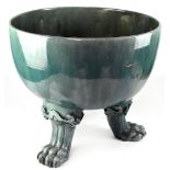 A large Chinese celadon-style footed jardinière in a green glaze, on three lion paw feet,