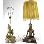 Two Thai brass table lamps in the form of seated deities, one male, height 37cm, the other female,