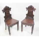 A pair of Victorian mahogany shield-back hall chairs with shaped apron and raised on reeded front