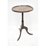 A George III oak occasional table with a lipped top, on a baluster turned column with tripod base,