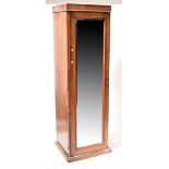 A late 19th/early 20th century walnut single door wardrobe with bevelled mirror plate,