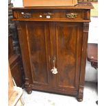 A Victorian mahogany cabinet with a single drawer above a pair of panelled cupboard doors enclosing