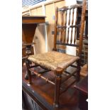 An 18th century rush seated nursing chair, the back rest with two rows of spindles,