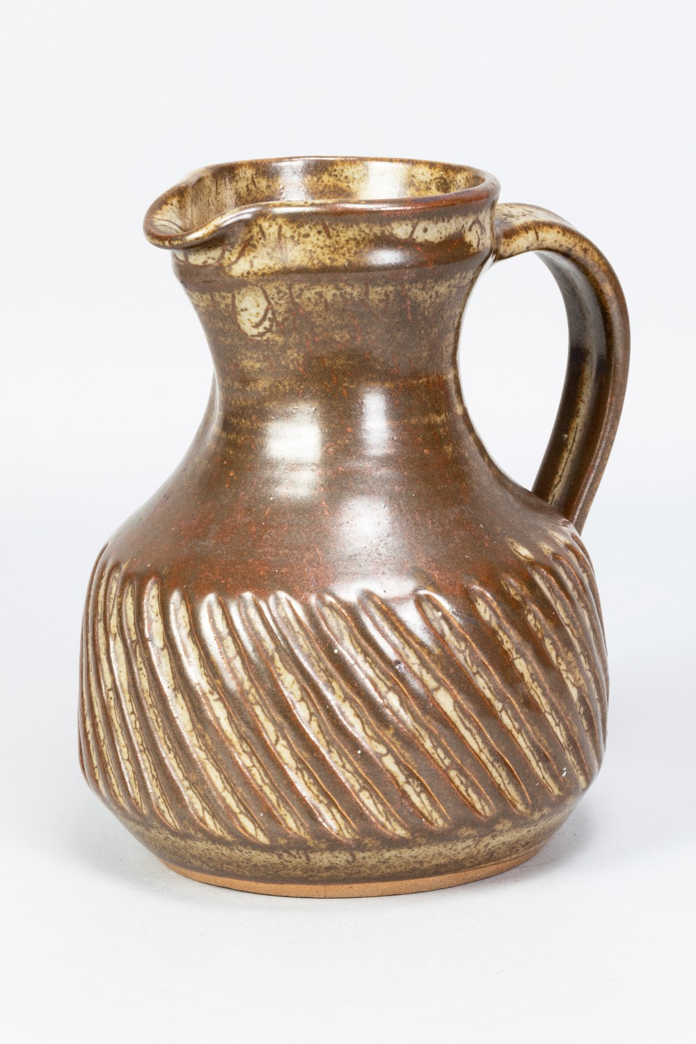 Aylesford Friars Pottery; a fluted stoneware jug covered in iron rich glaze, made 1960/70s,