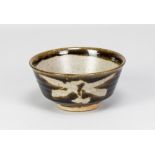 HELEN PINCOMBE (1908-2004); a stoneware chawan with wax resist decoration on tenmoku ground,
