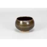 PAUL BARRON (1917-1983); a stoneware chawan covered in tenmoku and mottled green glaze, impressed