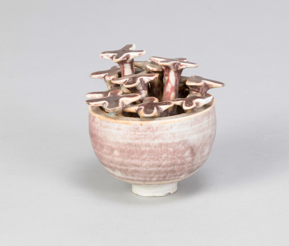 DEREK DAVIS (1926-2008); a small porcelain pot with flowers washed with copper red glaze, painted