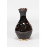 URSULA MOMMENS (1908-2010); a small stoneware bottle covered in tenmoku breaking to kaki glaze,