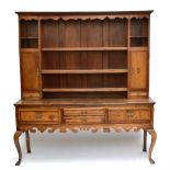 A late 18th century oak and elm dresser, the boarded back with three fixed shelves flanked by two