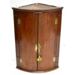 A George III oak bowfronted hanging corner cupboard with line inlaid detail to the door.