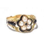 An early 19th century yellow metal and enamel mourning ring, set with a flower head formed by five