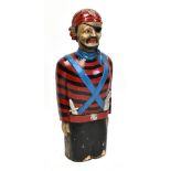 A late 19th/early 20th century carved and painted wooden figure head in the form of a pirate wearing