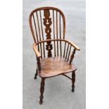 An 18th century elm and ash Windsor elbow chair, with crinoline stretcher, raised on turned column