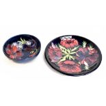 MOORCROFT; a circular plate decorated in 'Anemone' pattern on blue ground, diameter 26cm, together