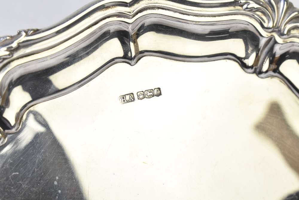 ATKIN BROS; a George V hallmarked silver salver raised on three scrolling supports, Sheffield - Image 2 of 5