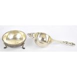 BARKER BROS LTD; a George V hallmarked silver tea strainer, Sheffield 1953, length 15cm, and a stand