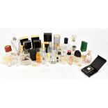 Approximately thirty-five vintage empty perfume bottles from designer brands, including Chanel Coco,