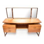 G-PLAN; a teak kneehole mirrored back floating dressing table, with an arrangement of three drawers,