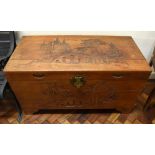 A large early 20th century Chinese carved camphor wood blanket box, the lid and front decorated with