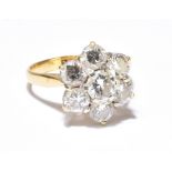 An 18ct yellow gold and diamond floral head ring, the central brilliant cut stone weighing approx