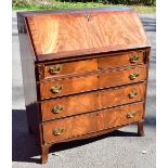 A 19th century mahogany bureau, the fall front enclosing pigeon holes and an arrangement of five