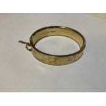 A 9ct gold hinged bangle, with engraved foliate detailing, weight approx 17g.Additional