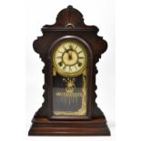 An American stained walnut gingerbread mantel clock, the circular dial with Roman numerals and