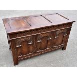 An early 20th century carved and stained oak coffer, with triple arched panelled front, on stile